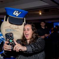Grad smiles taking selfie with Louie